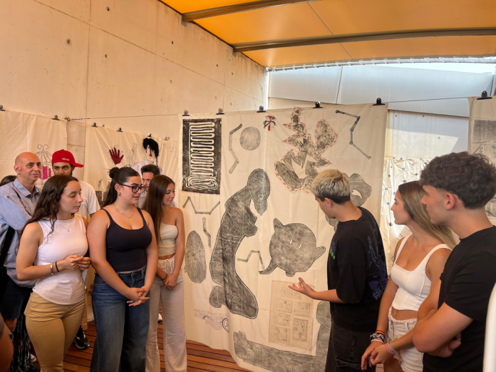 “En tránsito”: los estudiantes reflexionan sobre el desplazamiento a través del arte en Es Baluard La muestra, inaugurada este 5 de junio, forma parte de un proyecto educativo y artístico colaborativo vinculado a la exposición de Eugenio Dittborn Palma, 5 de junio de 2025. El espacio educativo de Es Baluard Museu d’Art Contemporani de Palma acoge desde hoy la inauguración de “En tránsito”, una propuesta artística participativa sobre el concepto de desplazamiento, protagonizada por estudiantes del segundo curso del Grado en Educación Primaria de la Universitat de les Illes Balears (UIB). El proyecto nace en el marco de la asignatura Educación Artística: Plástica y Visual. Didáctica en la Escuela Primaria, y se presenta como una obra colectiva fruto del trabajo de todo el curso académico, en diálogo con la exposición “Eugenio Dittborn. Pinturas Aeropostales”. A través de esta iniciativa, los alumnos han explorado las múltiples dimensiones del desplazamiento, tanto físico como simbólico, desde una perspectiva educativa, creativa y crítica. Colaboración entre arte, educación y comunidad La propuesta forma parte del programa “En tráfico”, que reúne a 15 grupos diferentes de centros educativos y entidades sociales, en colaboración con los artistas Tonina Matamalas y Blu, y con la participación de Aldana Areco de Librería Propia. Este entramado artístico-educativo busca potenciar el museo como espacio de encuentro, reflexión y creación compartida entre el mundo artístico, el ámbito escolar y la universidad. Paralelamente, el laboratorio GRAiE - Mus&Art Lab de la UIB lleva a cabo el proyecto de investigación educativa “Trayectos artísticos compartidos entre museo, escuela y universidad”, centrado en analizar los procesos de aprendizaje y creación artística en contextos educativos expandidos. Una experiencia transformadora La participación en “En tránsito” ha permitido a los futuros docentes experimentar de primera mano el potencial del arte como herramienta pedagógica y de pensamiento crítico. La muestra invita al público a recorrer una constelación de miradas jóvenes sobre el movimiento, el cruce de fronteras, la identidad y la memoria, cuestiones muy presentes en la obra de Dittborn y que los estudiantes han reinterpretado desde su propio lenguaje plástico. Con esta exposición, Es Baluard refuerza su compromiso con la educación y el arte como motores de transformación social, abriendo sus puertas a nuevas formas de creación colectiva y diálogo entre generaciones.