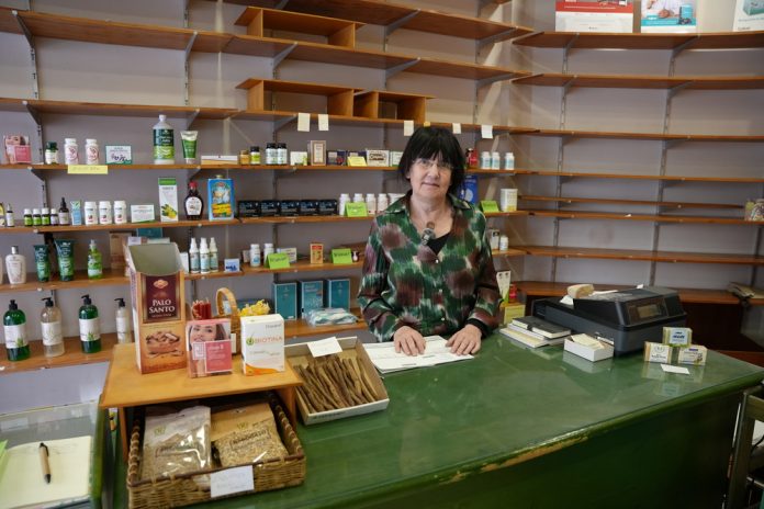 Ángels Fermollosa, el alma de una herboristería que se despide tras cuatro décadas: “Un comercio es vida para el barrio” Después de más de 40 años al frente de su herboristería, Ángels Fermollosa baja la persiana dejando mucho más que un negocio: una red de afectos, memoria y vida de barrio que hoy Palma empieza a perder. Palma, 20 de marzo de 2026. Hay negocios que venden productos y otros que construyen comunidad. El de Ángels Fermollosa ha sido, durante más de cuatro décadas, un poco de ambas cosas, pero sobre todo lo segundo. Su herboristería, pionera en Palma en el ámbito de la dietética y la alimentación saludable, cierra ahora sus puertas sin relevo generacional, dejando tras de sí una historia profundamente ligada a la vida cotidiana del barrio. “Yo abrí la tienda cuando mi hija tenía una semana, la crié aquí”, recuerda. Entre estanterías, consejos y clientes habituales, ha visto crecer no solo a sus hijas, sino también a generaciones enteras. “Es ver crecer a los hijos de mis clientes, es saber muchísimas cosas de su vida”, explica con emoción contenida. Mucho más que una tienda Para Ángels, su negocio nunca fue solo un medio de vida. “Es mucho más que una tienda… es un sitio en el que la gente lo tiene como referencia”, afirma. Y lo ejemplifica con escenas que hoy parecen casi de otro tiempo: vecinos que dejan las llaves por si acaso, hijos que piden que avisen si sus padres no pasan a comprar, conversaciones que van más allá del producto. “Un comercio da vida a un barrio”, sentencia. Y lanza una pregunta que ya empieza a resonar entre los vecinos: “¿Qué será de esta calle ahora sin esta tienda?”. A su cierre se suma el de otros negocios históricos cercanos, como el zapatero del barrio. “Van a haber cambios importantes y a veces no siempre es para mejor”, advierte. La dificultad de conservar el comercio tradicional Fermollosa pone palabras a una realidad cada vez más visible en Palma: la desaparición del pequeño comercio tradicional. “Si no hay relevo generacional, es prácticamente imposible”, explica. Sus propias hijas han seguido otros caminos profesionales, y el local, además, no es de su propiedad, lo que ha impedido un posible traspaso pese a que la tienda “está viva, funciona”. Ante este escenario, plantea una idea que suena casi utópica: “Que los municipios se hicieran cargo de estos locales y los mantuvieran como tiendas museo”. Mientras tanto, reivindica al menos la memoria: “Poner rótulos que digan ‘aquí hubo…’, para que la gente recuerde lo que fue este barrio”. Patrimonio más allá de los grandes monumentos Su compromiso con la ciudad no termina con el cierre. Ángels forma parte de ARCA, entidad dedicada a la defensa del patrimonio, donde ha centrado su labor en lo más cotidiano. “La catedral o la Lonja están claras, pero yo quiero defender la fuentecita del barrio, una fachada, una puerta… lo que forma parte de la historia de la gente”, explica. De hecho, su propia tienda ha sido durante años un punto de encuentro ciudadano. “Aquí he tenido sentados a vecinos, políticos, entidades… ha sido casi una oficina de ARCA”, cuenta. Y deja claro que seguirá vinculada: “Voy a continuar haciendo lo mismo, sin ninguna duda”. Una ciudad en transformación Con mirada crítica, también reflexiona sobre el modelo comercial actual. “Hay una invasión estética tan grande… luces LED, pantallas, colores… que impiden interpretar la ciudad”, señala. Frente a ello, defiende un comercio integrado en el entorno, con identidad y arraigo, lejos de la lógica de “explotar un local hasta agotarlo”. Para ella, el cambio no es solo económico, sino también cultural y urbano. Y considera que desde las instituciones “se podría hacer mucho más para evitar esta degeneración”. Un nuevo comienzo El cierre no es solo un final, también un punto de inflexión personal. Tras décadas de dedicación absoluta, Ángels mira ahora hacia un tiempo diferente. “Voy a poder hacer cosas que antes no podía: viajar, ir a conferencias, visitar museos…”, explica. “Es un regalo y un lujo, y lo voy a disfrutar”, concluye. Pero su legado queda. En cada cliente, en cada conversación, en cada rincón del barrio que durante años tuvo en su tienda un punto de referencia. Porque, como ella misma ha demostrado, hay negocios que no se cierran del todo: simplemente dejan de tener persiana.