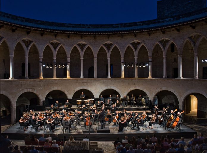 # La Orquesta Sinfónica Illes Balears abrirá el Festival Castell de Bellver con obras de Chaikovski y Brahms **El prestigioso violinista Sergei Dogadin actuará como solista en una velada dirigida por Pablo Mielgo que inaugurará una nueva edición de uno de los grandes acontecimientos culturales del verano mallorquín.** **Palma, 19 de junio de 2026.** La Orquesta Sinfónica Illes Balears dará el próximo jueves 25 de junio el pistoletazo de salida al Festival Castell de Bellver 2026 con un concierto que reunirá dos de las obras más destacadas del repertorio romántico universal en uno de los escenarios patrimoniales más emblemáticos de Mallorca. La actuación tendrá lugar a las 21.30 horas en el Castell de Bellver y estará dirigida por Pablo Mielgo, director titular de la formación balear. El programa combinará el virtuosismo del **Concierto para violín y orquesta en re mayor, op. 35** de Piotr Ilitx Chaikovski con la monumental **Sinfonía n.º 1 en do menor, op. 68** de Johannes Brahms. ## Sergei Dogadin, invitado de excepción La gran figura invitada de la noche será el violinista ruso **Sergei Dogadin**, considerado uno de los intérpretes más destacados de su generación y ganador de algunos de los concursos internacionales más prestigiosos del mundo. Dogadin asumirá el reto de interpretar una de las partituras más exigentes y apasionadas del repertorio violinístico, una obra cargada de lirismo, intensidad emocional y brillantez técnica que se ha convertido en una de las piezas más admiradas de la literatura para violín. ## Brahms para cerrar una noche de gran intensidad La segunda parte del concierto estará dedicada a la **Primera Sinfonía de Brahms**, una obra que marcó un antes y un después en la historia de la música sinfónica europea. Considerada una de las grandes creaciones del romanticismo alemán, la partitura destaca por su profundidad expresiva, su riqueza orquestal y la fuerza de un discurso musical que ha fascinado al público desde su estreno. Su célebre final servirá para poner el broche a una velada concebida para inaugurar el festival con solemnidad y brillantez. ## Una cita imprescindible del verano cultural mallorquín El Festival Castell de Bellver se ha consolidado como una de las principales propuestas culturales del verano en Mallorca, combinando grandes producciones sinfónicas con el incomparable entorno histórico del castillo gótico que domina la bahía de Palma. Con esta nueva edición, la Orquesta Sinfónica Illes Balears reafirma su apuesta por una programación de excelencia artística, acercando al público de las islas a grandes intérpretes internacionales y a algunas de las obras más representativas del repertorio clásico. Las entradas ya se encuentran a la venta a través de la página web de la Orquesta Sinfónica Illes Balears y también podrán adquirirse en las taquillas del Castell de Bellver una hora antes del inicio del concierto.