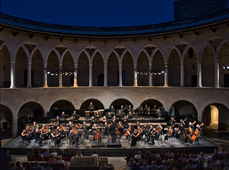 # La Orquesta Sinfónica Illes Balears abrirá el Festival Castell de Bellver con obras de Chaikovski y Brahms **El prestigioso violinista Sergei Dogadin actuará como solista en una velada dirigida por Pablo Mielgo que inaugurará una nueva edición de uno de los grandes acontecimientos culturales del verano mallorquín.** **Palma, 19 de junio de 2026.** La Orquesta Sinfónica Illes Balears dará el próximo jueves 25 de junio el pistoletazo de salida al Festival Castell de Bellver 2026 con un concierto que reunirá dos de las obras más destacadas del repertorio romántico universal en uno de los escenarios patrimoniales más emblemáticos de Mallorca. La actuación tendrá lugar a las 21.30 horas en el Castell de Bellver y estará dirigida por Pablo Mielgo, director titular de la formación balear. El programa combinará el virtuosismo del **Concierto para violín y orquesta en re mayor, op. 35** de Piotr Ilitx Chaikovski con la monumental **Sinfonía n.º 1 en do menor, op. 68** de Johannes Brahms. ## Sergei Dogadin, invitado de excepción La gran figura invitada de la noche será el violinista ruso **Sergei Dogadin**, considerado uno de los intérpretes más destacados de su generación y ganador de algunos de los concursos internacionales más prestigiosos del mundo. Dogadin asumirá el reto de interpretar una de las partituras más exigentes y apasionadas del repertorio violinístico, una obra cargada de lirismo, intensidad emocional y brillantez técnica que se ha convertido en una de las piezas más admiradas de la literatura para violín. ## Brahms para cerrar una noche de gran intensidad La segunda parte del concierto estará dedicada a la **Primera Sinfonía de Brahms**, una obra que marcó un antes y un después en la historia de la música sinfónica europea. Considerada una de las grandes creaciones del romanticismo alemán, la partitura destaca por su profundidad expresiva, su riqueza orquestal y la fuerza de un discurso musical que ha fascinado al público desde su estreno. Su célebre final servirá para poner el broche a una velada concebida para inaugurar el festival con solemnidad y brillantez. ## Una cita imprescindible del verano cultural mallorquín El Festival Castell de Bellver se ha consolidado como una de las principales propuestas culturales del verano en Mallorca, combinando grandes producciones sinfónicas con el incomparable entorno histórico del castillo gótico que domina la bahía de Palma. Con esta nueva edición, la Orquesta Sinfónica Illes Balears reafirma su apuesta por una programación de excelencia artística, acercando al público de las islas a grandes intérpretes internacionales y a algunas de las obras más representativas del repertorio clásico. Las entradas ya se encuentran a la venta a través de la página web de la Orquesta Sinfónica Illes Balears y también podrán adquirirse en las taquillas del Castell de Bellver una hora antes del inicio del concierto.